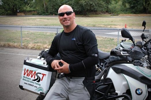 motorcycle instructor learning on motorcycle smiling