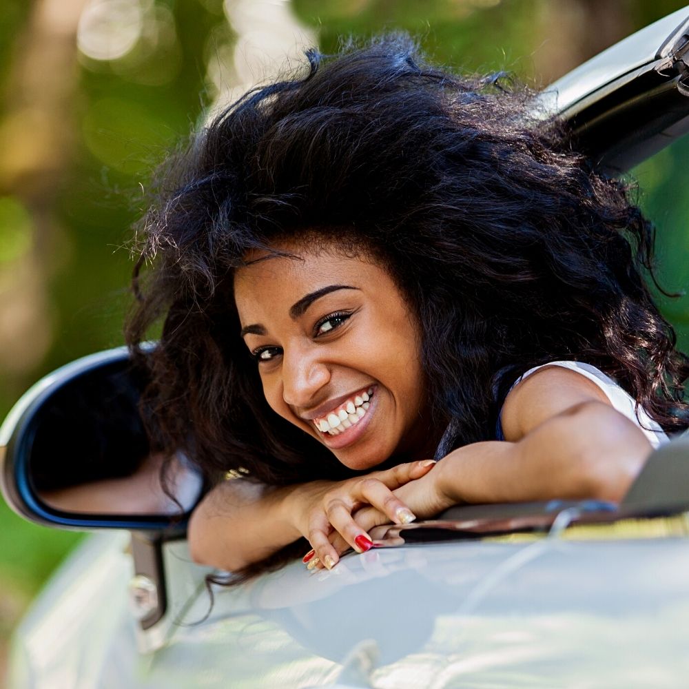 lynnwood driver education student learning out of the drivers window smiling